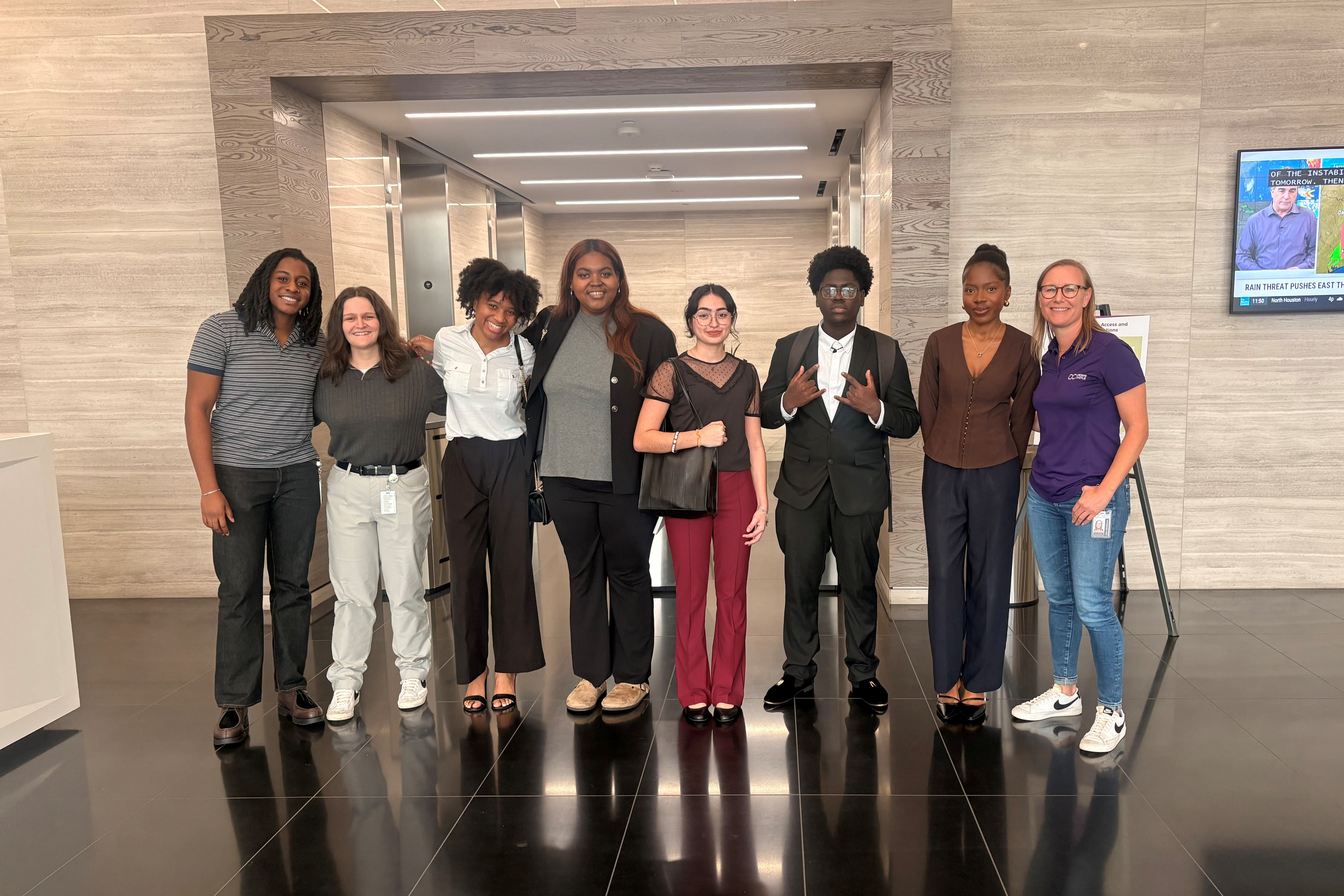 people in business attire in front of elevator bank. 