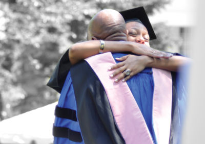College graduate hugging professor or staff member