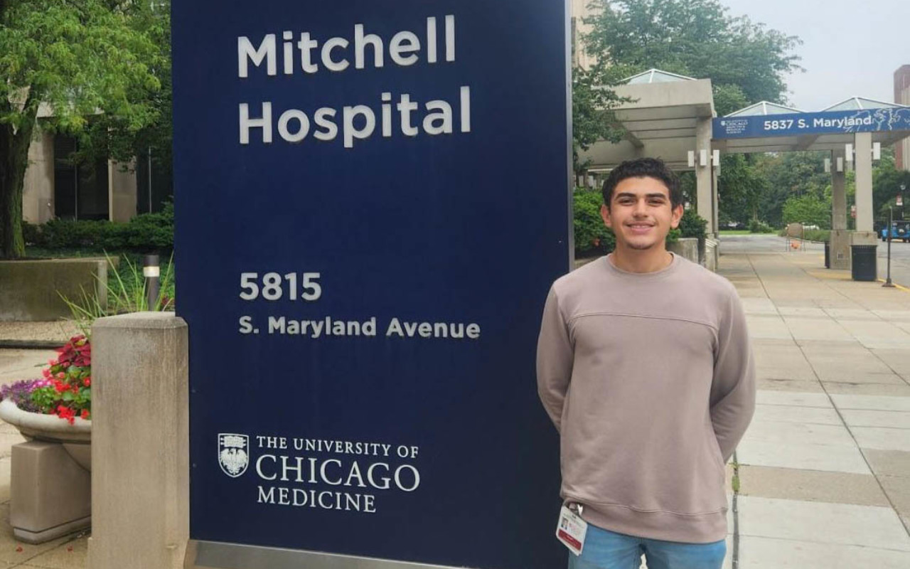 Man standing in front of hospital sign.