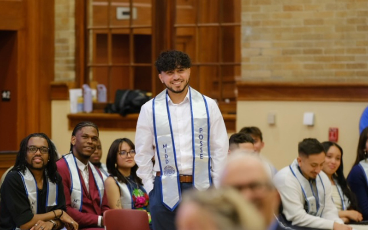 a man wearing a white shirt and smiling.