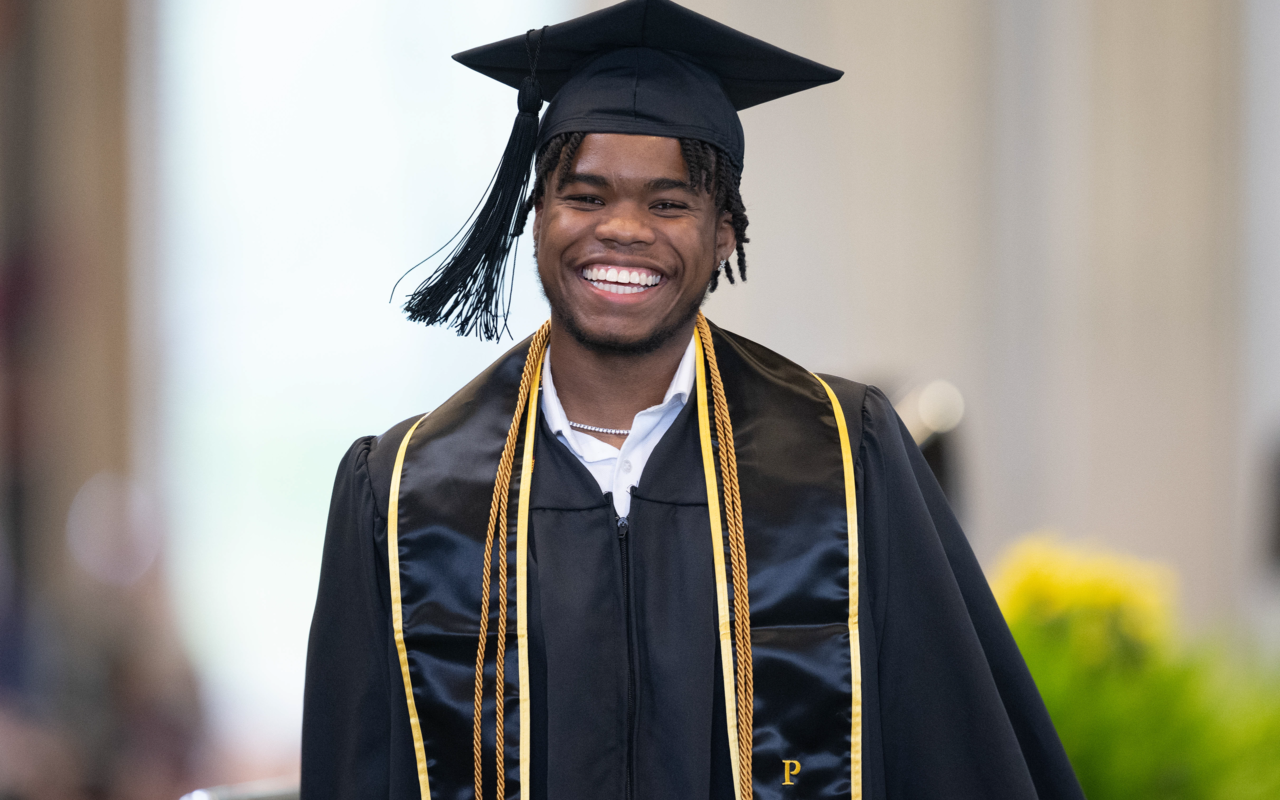 smiling graduate in cap and gown. 