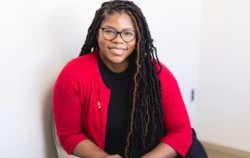 woman in red cardigan smiling.