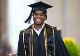 smiling graduate in cap and gown. 