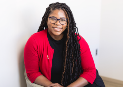 woman in red cardigan smiling.