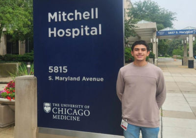 Man standing in front of hospital sign.