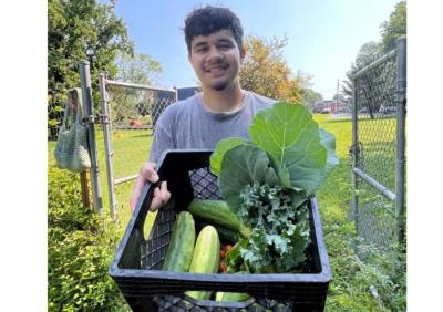 smiling person with a bunch of veggies.