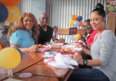 Posse Advisory Board Member Angel Johnson, Curtis Johnson, and guests enjoy crawfish on GiveNOLA Day